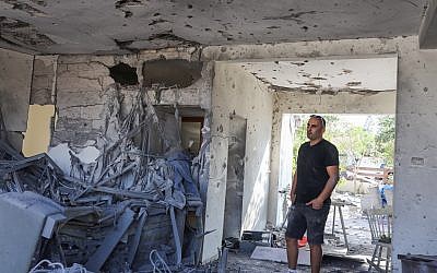 Un homme constate les dégât dans un immeuble d'Ashkelon frappé par une roquette du Hamas, le 13 novembre 2018. (Crédit : Nati Shohat/Flash90)