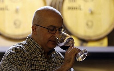 Alaa Mansur, directeur de la production au vignoble Haddad, goûte un échantillon a l'Eagle Distilleries, en Jordanie, le 31 octobre, 2018. (Crédit : KHALIL MAZRAAWI / AFP)