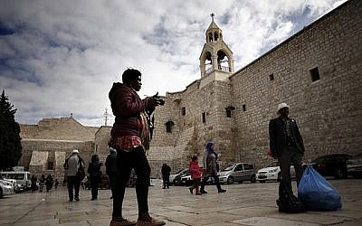 Touristes et pèlerins chrétiens se photographient devant l'Eglise de la Nativité en Cisjordanie, le 12 décembre 2018. (Crédit : THOMAS COEX / AFP)