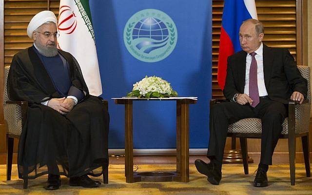 Sur cette photo du 9 juin 2018, le président russe Vladimir Poutine, (à droite), discute avec le président iranien Hassan Rouhani pendant une réunion à Qingdao, en Chine. (AP Photo/Alexander Zemlianichenko, Pool, File)