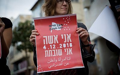 Une femme tient une pancarte disant qu'elle est en grève lors d'une manifestation à Tel Aviv, le 2 décembre 2018 (Crédit : Miriam Alster/Flash90)