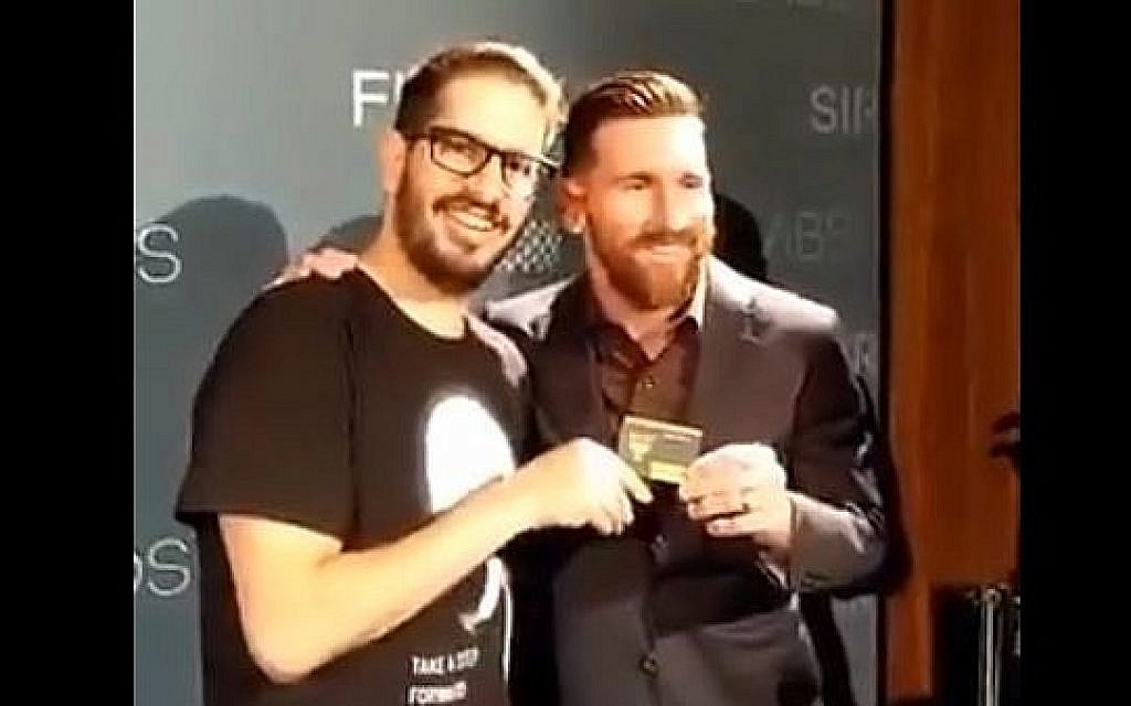 Lionel Messi (à droite), star du football argentin, reçoit sa carte de membre du fan club du Beitar Jerusalem des mains du propriétaire du club, Moshe Hogeg, lors d'un événement à Barcelone, Espagne, en décembre 2018. (Capture d'écran : Twitter)