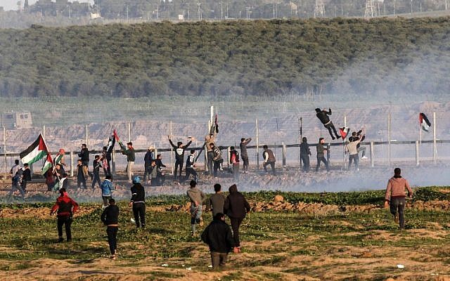 Des manifestants palestiniens tentent de franchir la barrière de sécurité avec Israël lors d'affrontements à la suite d'une manifestation le long de la frontière à l'est de la bande de Gaza le 4 janvier 2019. (Crédit : Saïd Khatib/AFP)