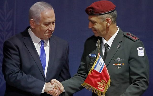 Le nouveau chef d'Etat-major Aviv Kochavi, à droite, serre la main au Premier ministre Benjamin Netanyahu lors d'une cérémonie de passation de pouvoir au siège du ministère de la Défense à Tel Aviv (Crédit : JACK GUEZ / AFP)