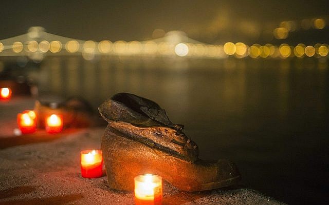 Des bougies brûlent devant les chaussures en fonte du Mémorial de la Shoah sur le quai du Danube, pendant la Journée internationale de commémoration de la Shoah à Budapest, Hongrie, le mercredi 27 janvier 2016. (Balazs Mohai/MTI via AP)