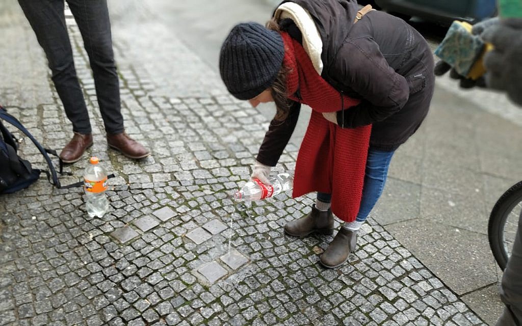 Des bénévoles nettoient des "stolpersteine" dans le quartier de Kreuzberg à Berlin lors de la Journée internationale de commémoration de la Shoah, le 27 janvier 2019. (Yaakov Schwartz/Times of Israel)
