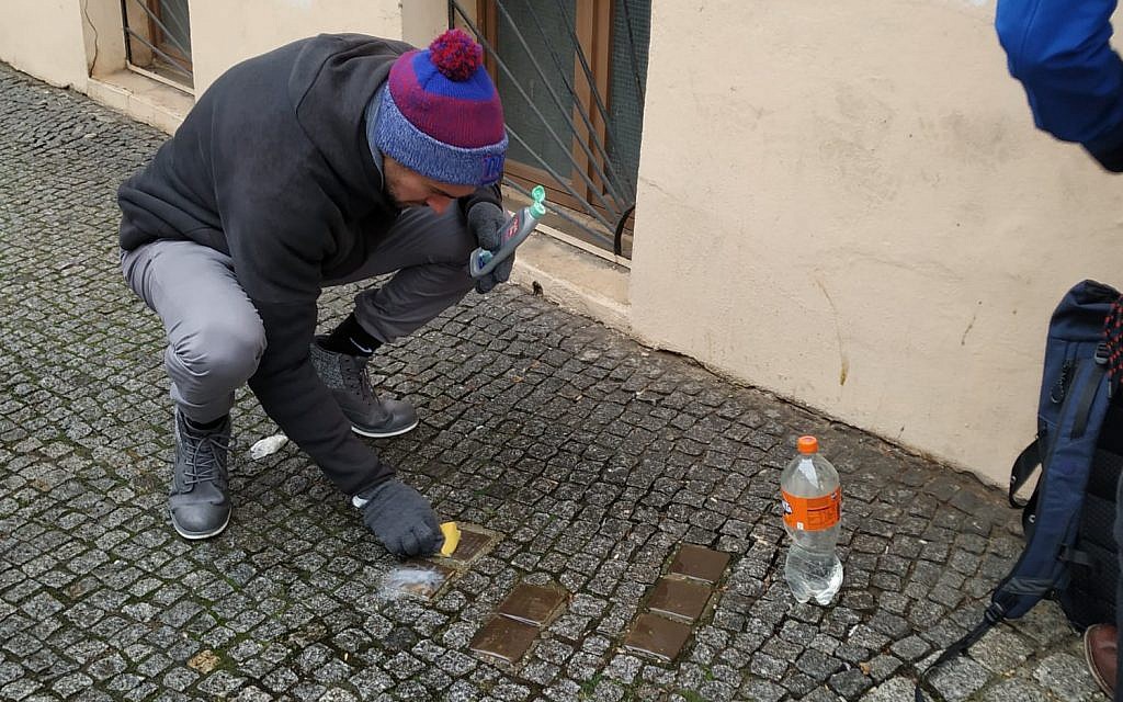 Des bénévoles nettoient des "stolpersteine" dans le quartier de Kreuzberg à Berlin lors de la Journée internationale de commémoration de la Shoah, le 27 janvier 2019. (Yaakov Schwartz/Times of Israel)