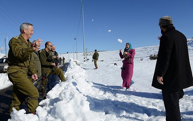 Le chef d'état-major de Tsahal de l'époque, Benny Gantz, fait une bataille de boules de neige avec une famille palestinienne le long de la route 60 en Cisjordanie, le 15 décembre 2013. (Judah Ari Gross / Armée israélienne)
