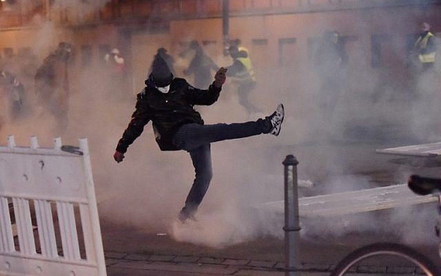 Des émeutiers jettent des cartouches de gaz lacrymogènes lors d'affrontements avec la police lors d'une manifestation antigouvernementale organisée par le mouvement des "Gilets jaunes" à Strasbourg, dans l'est de la France, le 2 février 2019. (Crédit : FREDERICK FLORIN / AFP)