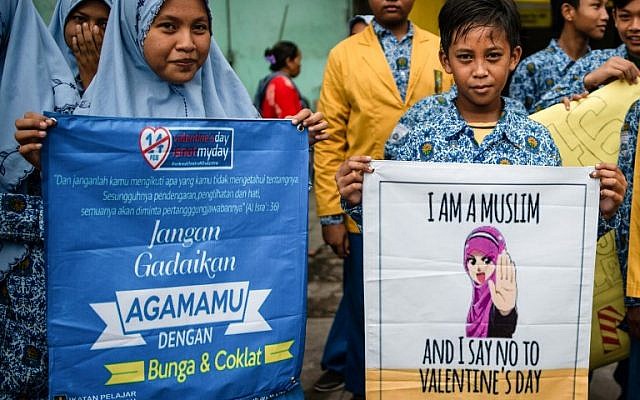 Une centaine de lycéens de Surabaya, la deuxième ville d'Indonésie, manifestent contre la tradition occidentale de la Saint-Valentin. "Dites non maintenant à la Saint-Valentin!" ou "Désolée pour la Saint-Valentin, je suis musulmane", peut-on lire sur les pancartes. (Crédit : .Juni Kriswanto / AFP)