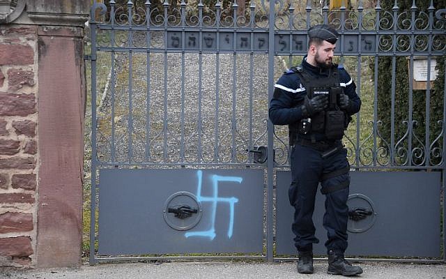 Une photo prise à Quatzenheim, France, le 19 février 2019 montre des croix gammées peintes sur le portail d'un cimetière juif, le jour d'une marche nationale contre la recrudescence des actes antisémites. - (Crédit : Frederick FLORIN / AFP)