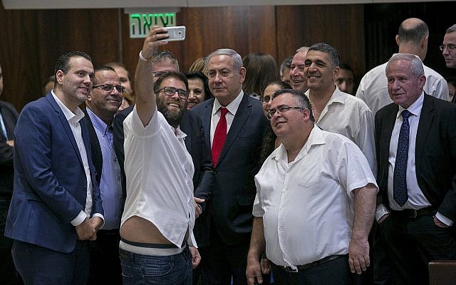 Le député du Likud Oren Hazan se prend en photo avec le Premier ministre Benjamin Netanyahu, au centre et des confrères du Likud à l'issue du vote sur l'Etat-nation à la Knesset le 19 juillet 2018. (Crédit : AP/Olivier Fitoussi)