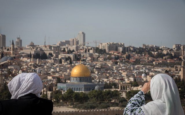 Des touristes contemplent le Dôme du Rocher et le mont du Temple depuis le belvédère du mont des Oliviers qui surplombe la Vieille Ville de Jérusalem, le 28 novembre 2018. (Crédit : Yonatan Sindel/Flash90)