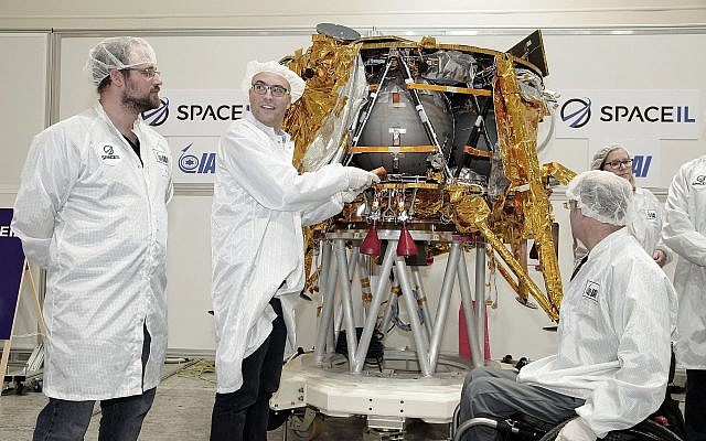 Yariv Bash, (à droite), Yonatan Winetraub, (au centre), et Kfir Damari, les fondateurs de SpaceIL, insérant une capsule témoin dans le vaisseau spatial Beresheet, le 17 décembre 2018. (Yoav Weiss)