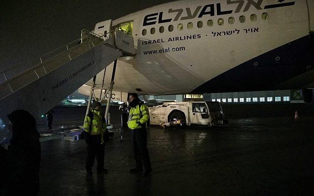 Des membres d'équipage se tiennent au pied de l'avion endommagé du Premier ministre Benjamin Netanyahu. (Crédit : Raphael Ahren/Times of Israel)