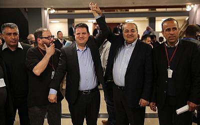 Les députés Ayman Odeh et Ahmad Tibi se réjouissent après avoir soumis une liste commune de candidats de leurs partis Hadash et Taal à la commission centrale électorale de la Knesset, le 21 février 2019. (Crédit : Hadash)