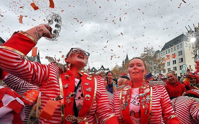 De fêtards en rouge célèbrent le lancement de la saison du carnaval dans les rues de Cologne en Allemagne, le 11 novembre 2018. (AP Photo/Martin Meissner)
