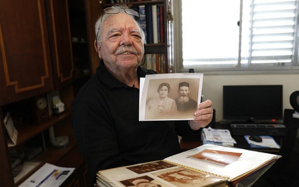 Samy Gryn, 78 ans,un des rares rescapés de la rafle du Vél d'Hiv en juillet 1942, montre une photo des proches, durant une interview à Tel Aviv, le 25 février 2019. (Crédit : MENAHEM KAHANA / AFP)