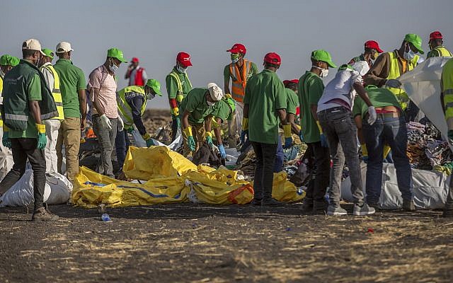 Les secours collectent des vêtements et autres matériels sous la supervision des enquêteurs sur les lieux du crash d'un Boeing 737 d'Ethiopian Airlines peu après le décollage avec 157 personnes à bord près de Bishoftu, en Ethiopie, le 12 mars 2019 (Crédit : AP Photo/Mulugeta Ayene)