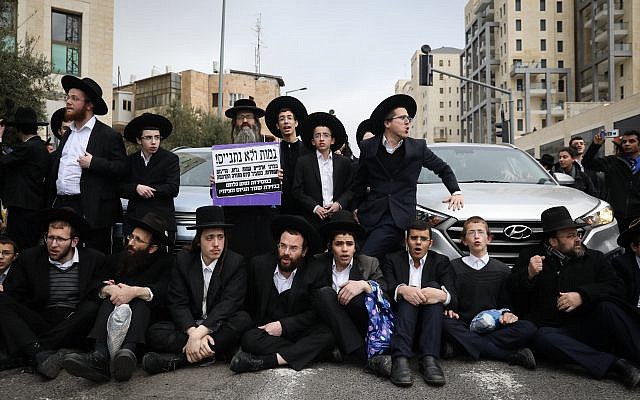 Des Juifs ultra-orthodoxes protestent contre l'arrestation d'un jeune homme qui a refusé de se présenter au bureau d’enrôlement de l'armée, à Jérusalem, le 7 mars 2019. (Crédit : Noam Revkin Fenton/Flash90)