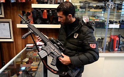 Un client inspecte un fusil vendu dans une armurerie à Mossoul, dans le nord de l'Irak, le 28 janvier 2019. (Crédit photo : Zaid AL-OBEIDI / AFP)