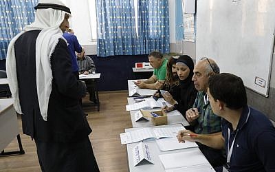 Un Arabe israélien se prépare à voter aux élections parlementaires israéliennes dans un bureau de vote installé dans une école à Taibé, dans le nord du pays, le 9 avril 2019. (Crédit : Ahmad Gharabli/AFP)