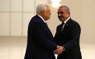 Le président de l'Autorité palestinienne Mahmoud Abbas, à gauche, serre la main du nouveau Premier ministre Mohammad Shtayyeh dans la ville de Ramallah, en Cisjordanie, le 13 avril 2019. (Crédit : Abbas Momani/AFP)