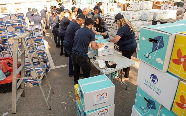 Dés bénévoles de Latet empaquetant des boites pour Pessah. (Crédit photo : Facebook/Latet)