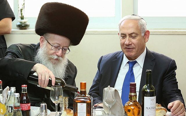 Le Premier ministre Benjamin Netanyahu est reçu par le ministre de la Santé Yaakov Litzman du parti Yahadout HaTorah (à gauche), lors d'un repas pour célébrer la naissance du petit-fils de Litzman, le 18 juin 2017. (Shlomi Cohen/FLASH90)