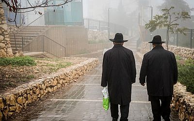 A titre d'illustration : Des hommes ultra-orthodoxes marchent sous la pluie et le brouillard à Safed, le 18 décembre 2018. (David Cohen/Flash90)