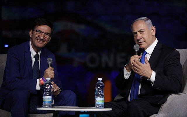 Le Premier ministre de l'époque, Benjamin Netanyahu, à droite, et le rédacteur en chef d'Israel Hayom, Boaz Bismuth, s'expriment lors du forum Israel Hayom à Jérusalem, le 27 juin 2019. (Crédit : Gideon Markovitz)