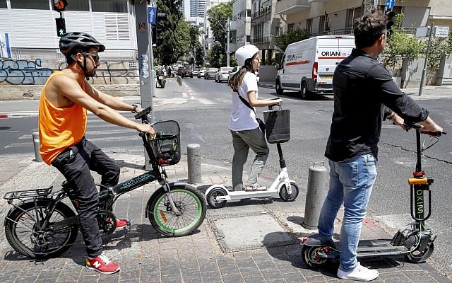 Des utilisateurs de trottinettes électriques dans les rues de Tel Aviv, le 30 mai 2019. (Crédit : JACK GUEZ / AFP)