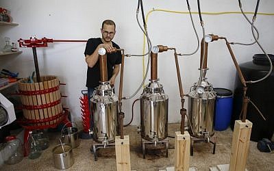 Le distillateur américano-palestinien Nader Muaddi attend que l'alcool soit distillé dans le village de Beit Jala, en Cisjordanie, près de Bethléem, le 16 juin 2019. (Crédit : HAZEM BADER / AFP)