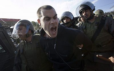 Photo d'illustration : L'activiste de gauche Jonathan Pollak est arrêté par les soldats israéliens durant une manifestation dans le village de Nabi Saleh, près de Ramallah, le 22 janvier 2010. (Crédit : AP Photo/Bernat Armangue)