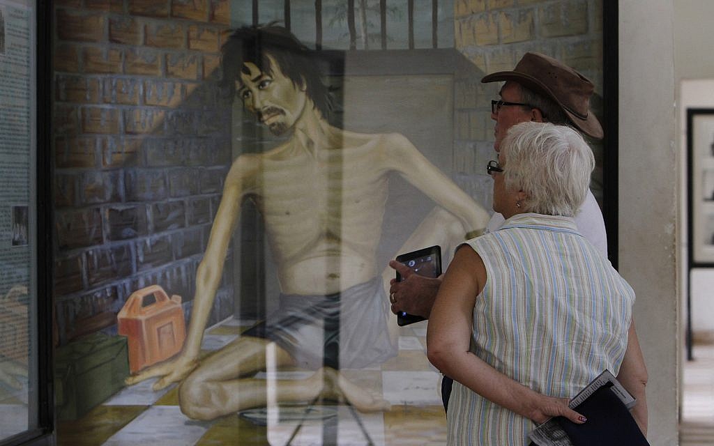 Photo d'illustration : Sur cette photo du 10 juillet 2014, des touristes regardent une peinture dépeignant les tortures des Khmers rouges au musée du génocide  Tuol Sleng, qui était avant la prison Khmer rouge la plus célèbre à   Phnom Penh, au Cambodge (Crédit : AP Photo/Heng Sinith)