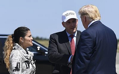 Le président Donald Trump, à droite, salue le représentant de New York Républicain Lee Zeldin, au centre, et son épouse Diana Zeldin, à gauche, après leur arrivée à l'aéroport Francis S. Gabreski à  Westhampton Beach, New York, le 9 août 2019 (Crédit : AP Photo/Susan Walsh)