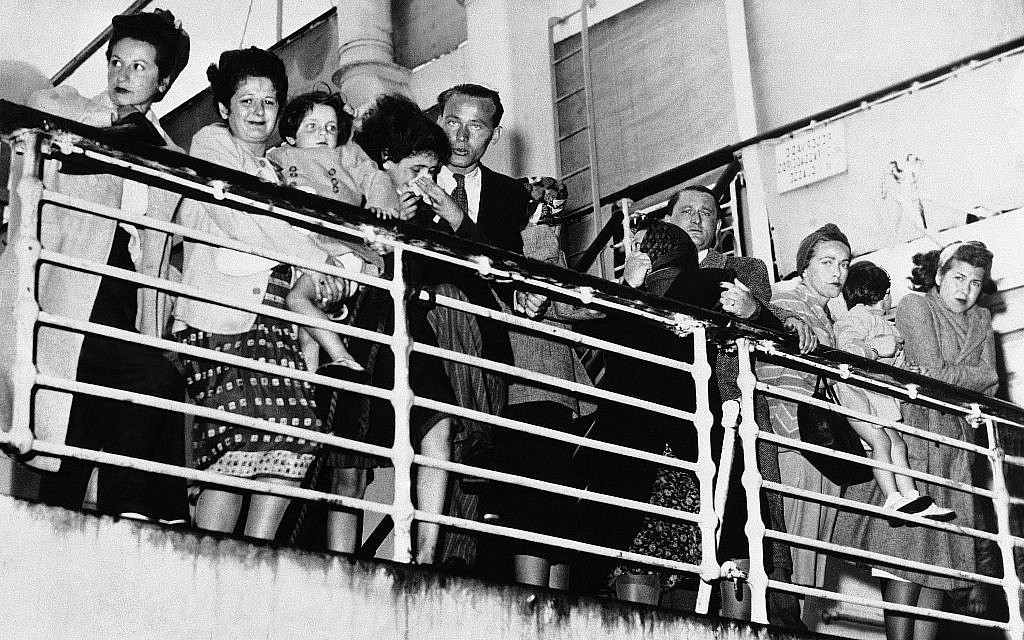 Des réfugiés européens, qui se sont vu refuser l'entrée aux États-Unis à à New York et au Mexique à Veracruz, se tiennent sur le pont du bateau portugais, le Quanza, discutent avec des proches à quai à Norfolk, en Virginie, où le bateau s'est arrêté pour faire le plein, le 11 septembre 1940. (Crédit : AP Photo)