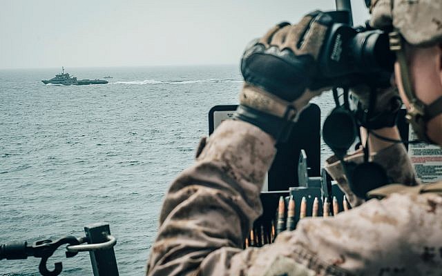 Un marine américain observe un vaisseau d'attaque iranien depuis l'USS John P. Murtha lors d'un transit dans le détroit d'Ormuz, le 18 juillet 2019. (Crédit : Corps des marines des États-Unis par le sergent d'état-major Donald Holbert)