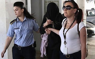 Des officiers de police escortent une jeune femme britannique de 19 ans, (au centre), au tribunal de Famagusta dans la ville de Paralimni, à Chypre, lundi 29 juillet 2019. (AP/Petros Karadjias)