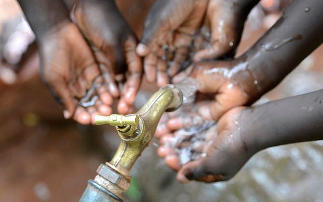 Image d'enfants africains qui boivent de l'eau d'un robinet (borgogniels; iStock par Getty Images)