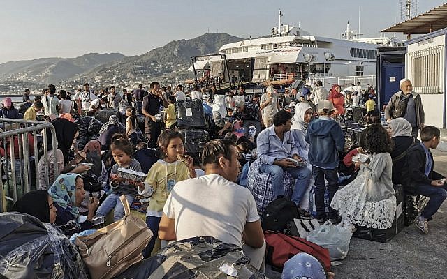 Des réfugiés et migrants attendent d'embarquer sur l'île de Lesbos, le 2 septembre 2019. (Crédit : STRINGER / AFP)