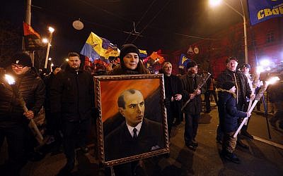 En ce 1er janvier 2019, photo de dossier, des militants de divers partis nationalistes portent des torches, des drapeaux nationaux ukrainiens et un portrait de Stepan Bandera lors d'un rassemblement à Kiev, en Ukraine. (AP Photo/Efrem Lukatsky, File)