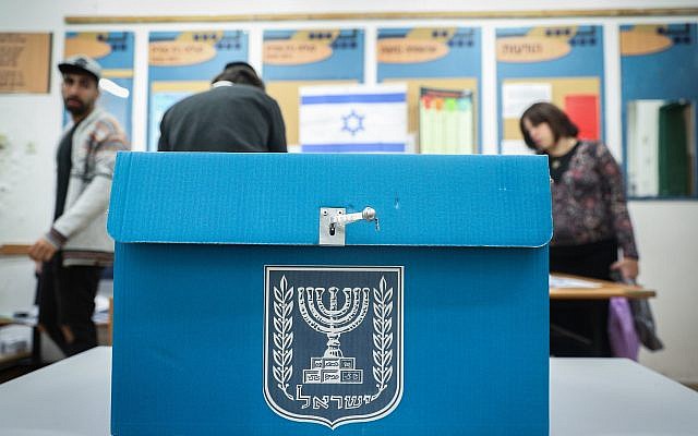 Des Israéliens déposent leur bulletin de vote dans l'urne d'un bureau de vote de Jérusalem, durant les élections législatives pour la 21e Knesset, le 9 avril 2019.(Crédit : Yonatan Sindel/Flash90)