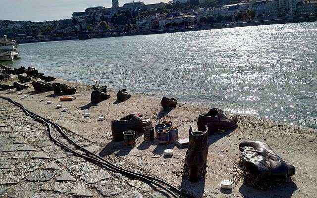 Des bougies posées à côté des souliers en fonte du mémorial aux victimes de la Shoah sur les rives du Danube à Budapest, le 22 septembre 2019 (Crédit : Yaakov Schwartz/ Times of Israel)