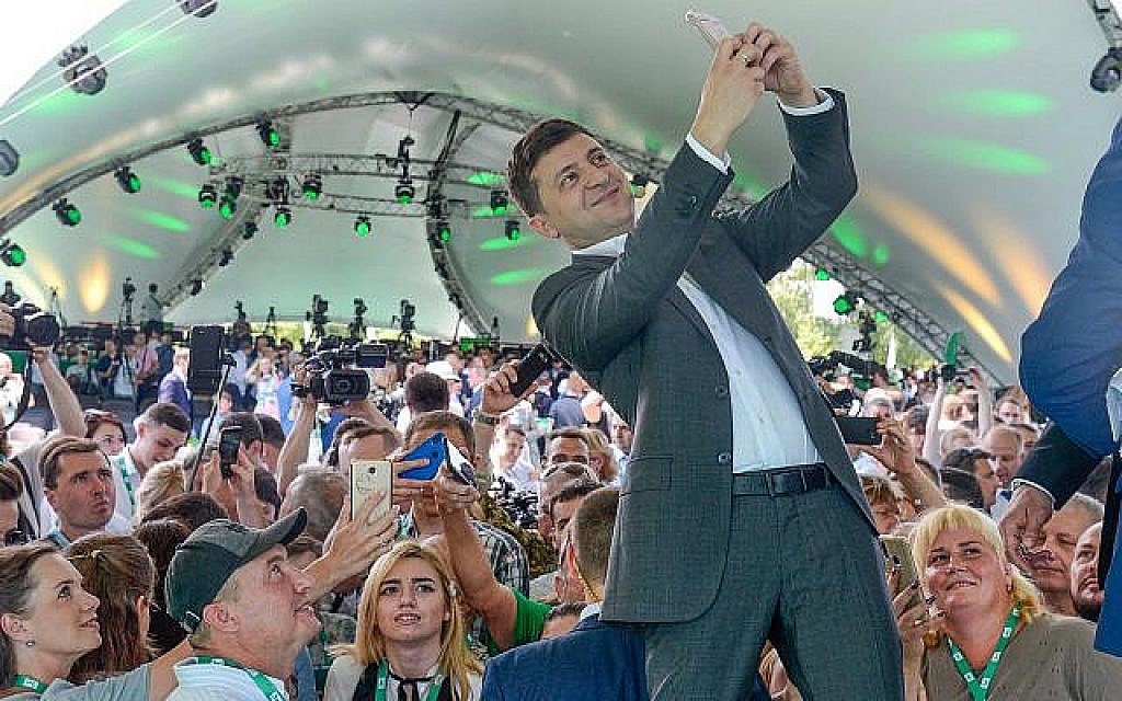 Le président ukrainien Volodymyr Zelensky prend un selfie au premier congrès de son parti, appelé Serviteur du peuple, dans le Jardin botanique municipal, Kiev, Ukraine, le 9 Juin 2019. (AP Photo/Zoya Shu)