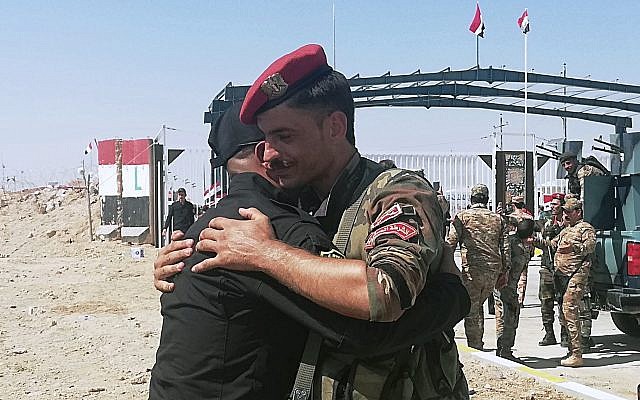 Des gardes frontière syriens et irakiens se congratulent lors de la cérémonie d'ouverture de la frontière entre la ville irakienne de Qaim et la ville syrienne de Boukamal dans la province d'Anbar, en Irak, le 30 septembre 2019. (AP Photo/Hadi Mizban)