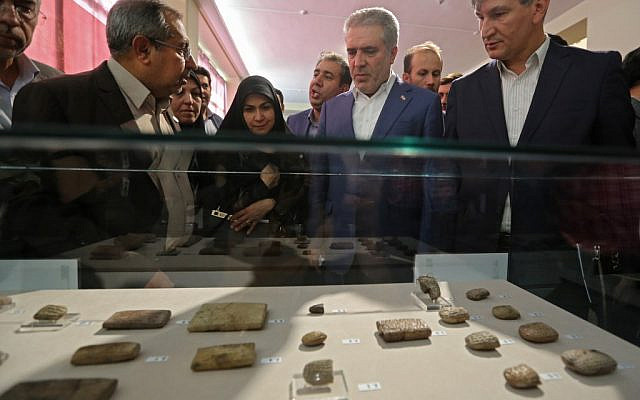 Le ministre iranien de la Culture Ali Asghar, au centre, regarde les tablettes antiques restituées à l'Iran par les Etats-Unis le 2 octobre 2019. (Crédit : ATTA KENARE / AFP)