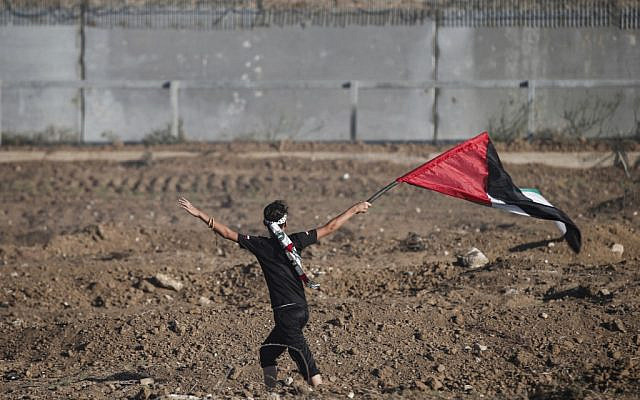 Un jeune manifestant brandit un drapeau palestinien alors qu'il manifeste près de la barrière frontalière avec Israël à l'est de la ville de Gaza, le 4 octobre 2019. (MAHMUD HAMS / AFP)