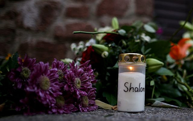 Des bougies et des fleurs à un mémorial improvisé devant la synagogue de Halle,  , au lendemain d'une fusillade antisémite meurtrière, le 10 octobre 2019 (Crédit : Ronny Hartmann/AFP)