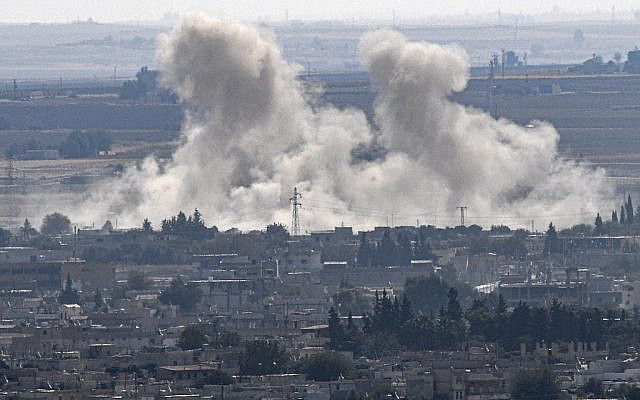 De la fumée monte de la ville syrienne de Ras al-Ain, du côté turc de la frontière dans le district de Ceylanpinar, à Sanliurfa, le 15 octobre 2019, lors de la première semaine de l'opération militaire turque contre les forces kurdes. (Crédit : Ozan KOSE / AFP)